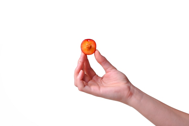 La mujer sostiene la ciruela en las manos sobre un fondo blanco aislado. idea y concepto de alimentación saludable.