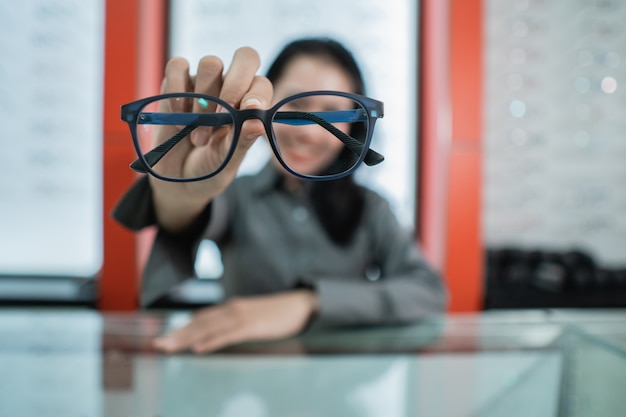 Una mujer sostiene las gafas de su elección en la clínica oftalmológica