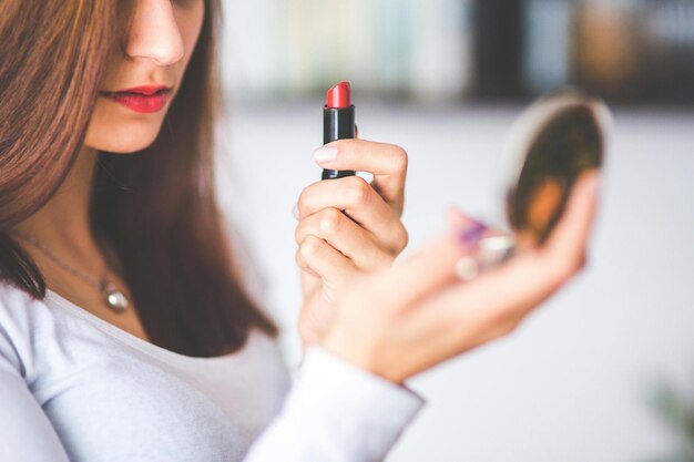 una mujer sostiene un lápiz labial que dice "lápiz labial"