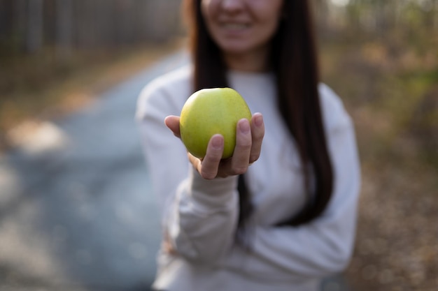 Foto una mujer sostiene una manzana verde en la mano