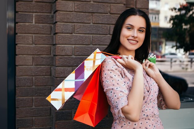 Mujer sostiene muchas bolsas después de ir de compras