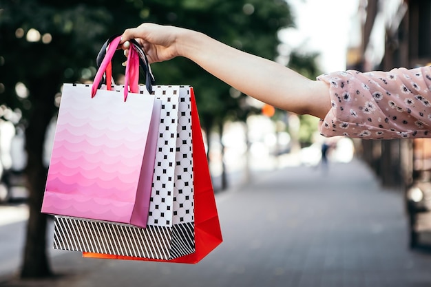 Mujer sostiene muchas bolsas después de ir de compras