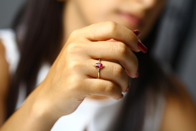 Una mujer sostiene una piedra rosa en su dedo.