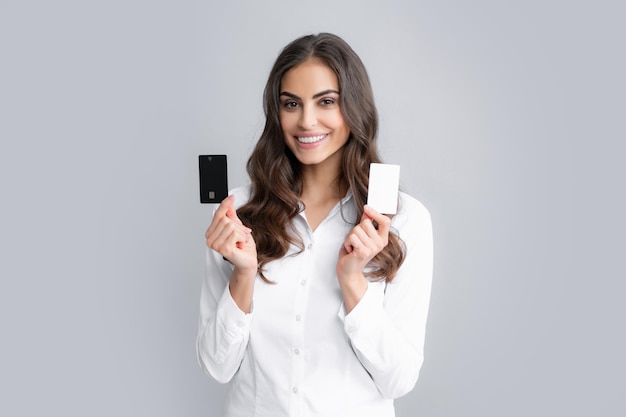 Mujer sostiene plantilla maqueta tarjeta de crédito bancaria con servicio en línea aislado sobre fondo gris Feliz atractiva joven mostrando crédito