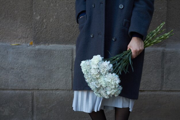 La mujer sostiene el ramo floral al aire libre