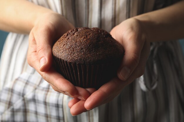 Mujer sostiene sabroso muffin de chocolate, de cerca