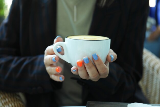 Mujer sostiene una taza de delicioso café, cerrar