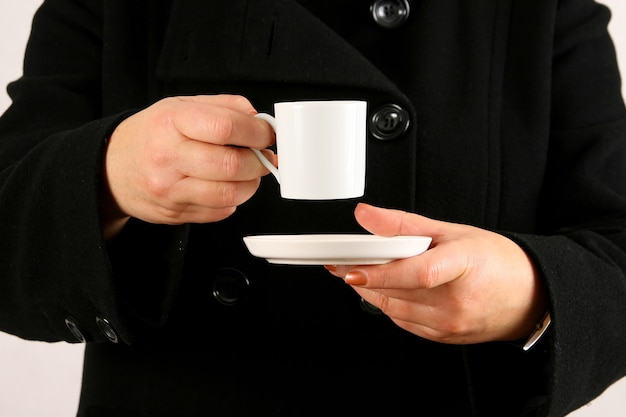 Foto una mujer sostiene una taza llena de té o café negro