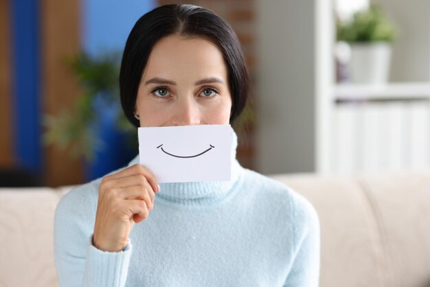 La mujer sostiene un trozo de papel con una sonrisa