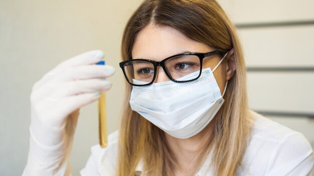 Una mujer sostiene un tubo de ensayo con un análisis de orina. Concepto de diagnóstico y análisis. Concepto de salud