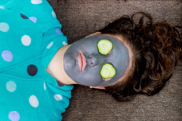 Mujer de spa aplicando máscara de limpieza facial tratamientos de belleza máscara en la cara de una joven