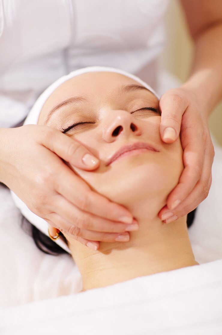 Mujer en el spa de belleza recibiendo un masaje facial