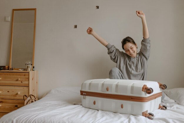 Foto mujer con su equipaje en la cama blanca en casa