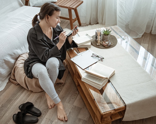 Foto una mujer en su escritorio con libros y un cuaderno está trabajando o estudiando de forma remota.