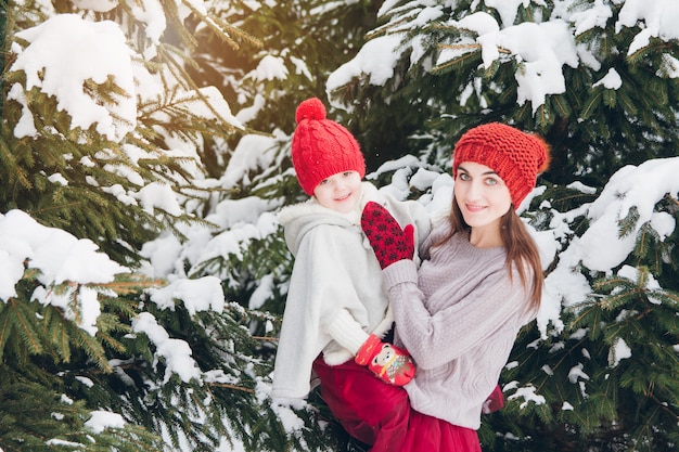 Mujer y su hija se divierten en el bosque de invierno