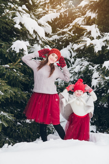 Mujer y su hija se divierten en el bosque de invierno