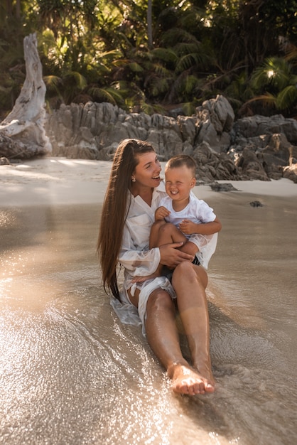 Mujer con su hijo en la orilla del mar