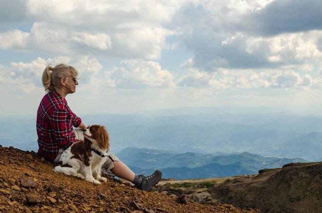 Foto la mujer y su perro cavalier king charles spaniel están viendo el pintoresco paisaje montañoso