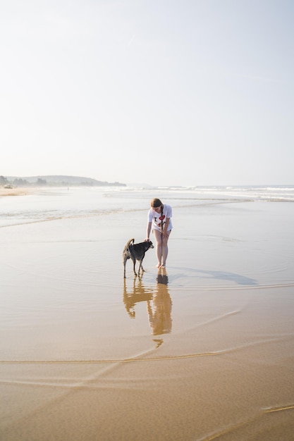 Una mujer y su perro en la playa.