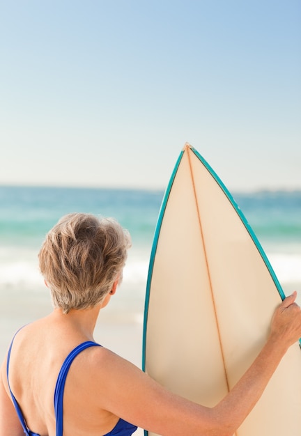 Mujer con su tabla de surf en la playa