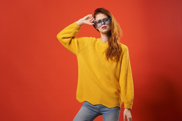 Foto mujer con suéter amarillo posando gafas azules moda foto de alta calidad