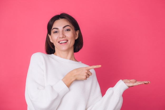 Mujer en suéter blanco casual en pared roja