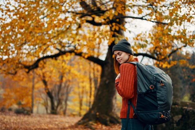 Mujer en un suéter camina en el parque en otoño naturaleza paisaje aire fresco modelo mochila