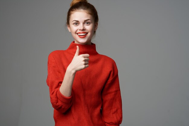 Mujer con suéter rojo gafas estudio moda estilo de vida fondo claro Foto de alta calidad