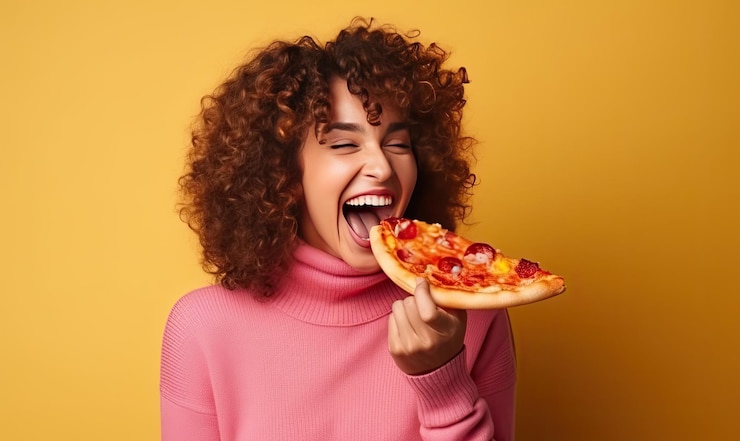 Foto una mujer con un suéter rosa comiendo una rebanada de pizza