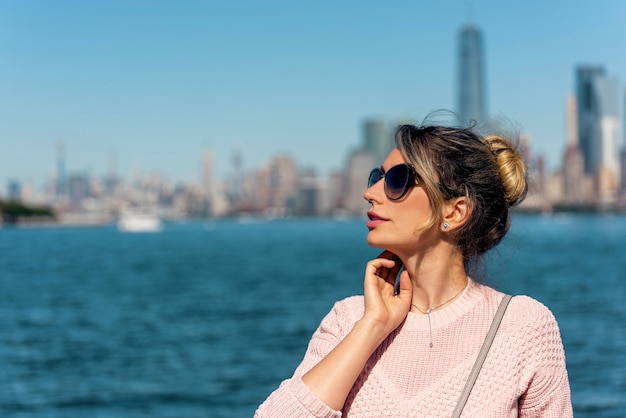 Mujer en suéter rosa posando en Nueva York