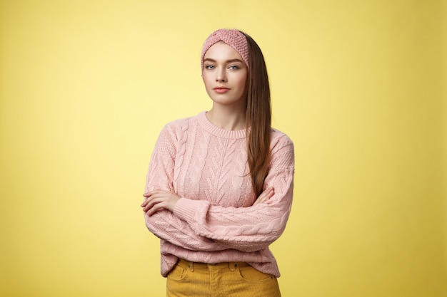 Mujer con suéter rosa sobre amarillo