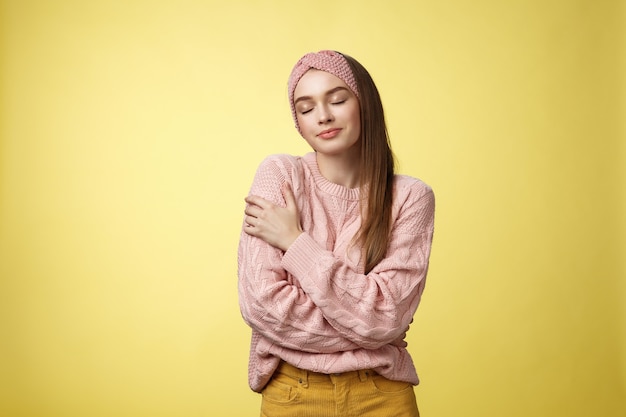 Mujer con suéter rosa sobre amarillo