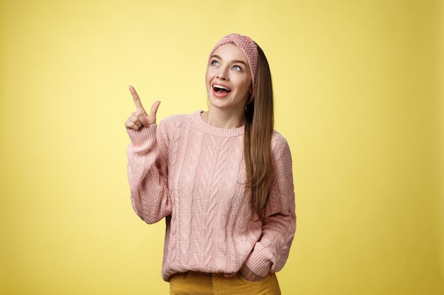 Mujer con suéter rosa sobre amarillo