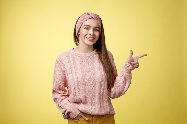 Mujer con suéter rosa sobre amarillo