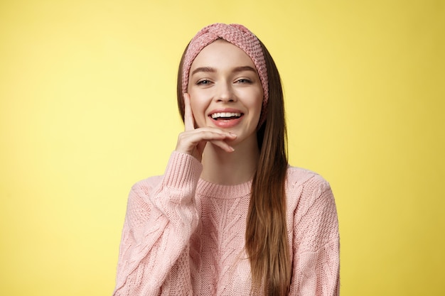 Mujer con suéter rosa sobre amarillo