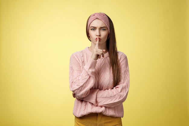 Mujer con suéter rosa sobre amarillo