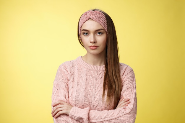 Mujer con suéter rosa sobre amarillo