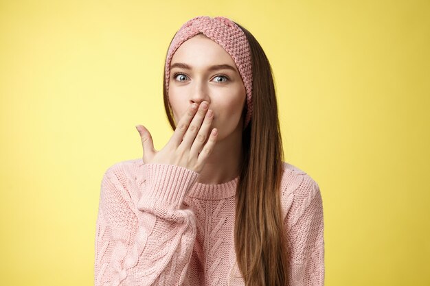 Mujer con suéter rosa sobre amarillo