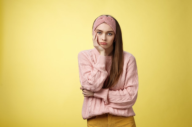 Mujer con suéter rosa sobre amarillo