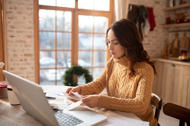 Mujer de suéter trabajando en un portátil