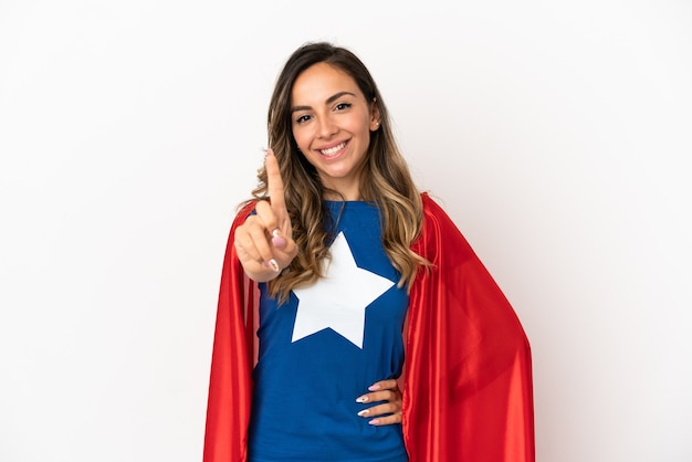 Mujer superhéroe sobre fondo blanco aislado mostrando y levantando un dedo
