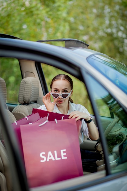 Mujer con sus bolsas de compras en el coche