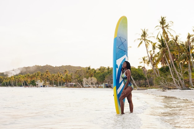 Mujer con tabla de surf sup