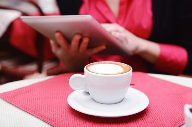 Mujer con tablet PC en la cafetería.