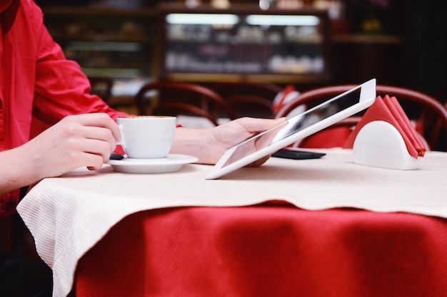 Mujer con tablet PC en la cafetería.