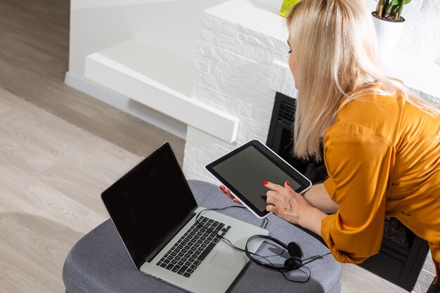 Mujer con tableta digital por chimenea en casa