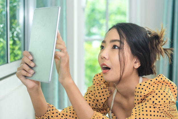 Mujer con tableta para tienda de publicidad en internet de tecnología de redes sociales