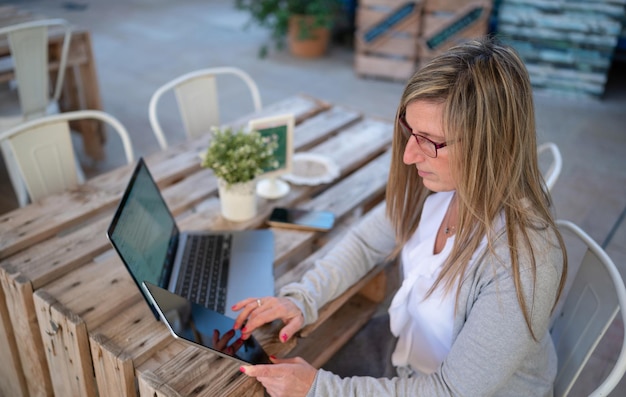 Mujer con una tableta trabajando en una cafetería.