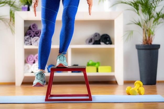 Mujer con taburete de salto durante el entrenamiento