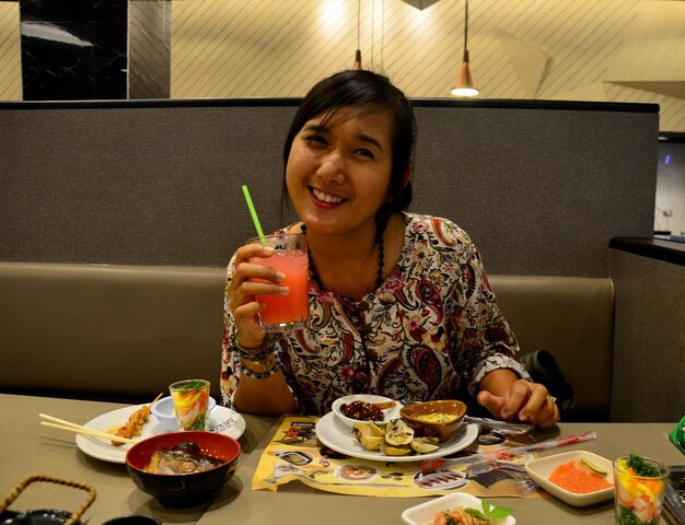 Mujer tailandesa comiendo buffet japonés